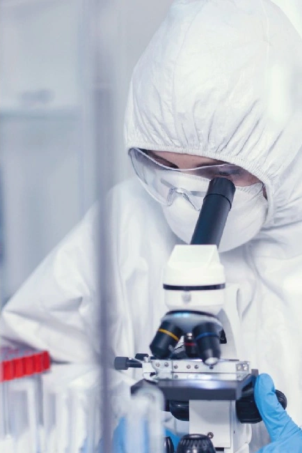 Profesional de laboratorio trabajando con microscopio, del portafolio de SOFTCAPS